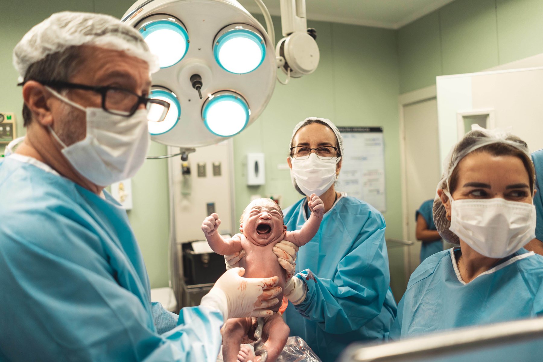 Equipe médica apresenta o recém-nascido à família